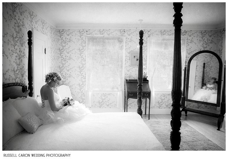 Bride sitting on a bed at Glen Magna Farms, Manor House, Danvers, MA