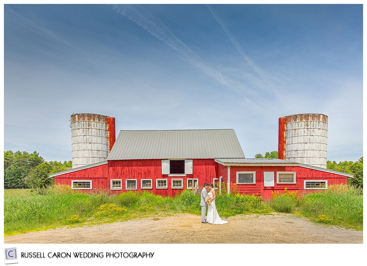 Bride and groom in front of barn