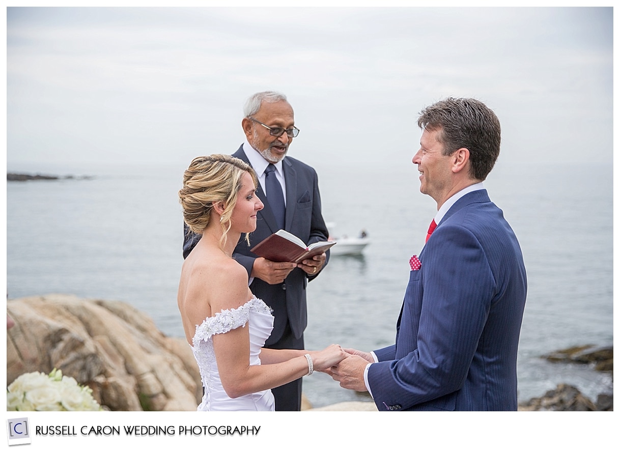 Bride and groom during ceremony on the rocks in Kennebunkport