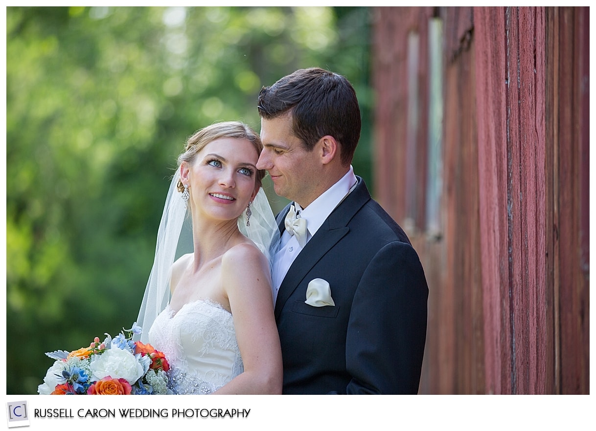 Bride and groom in front of barn