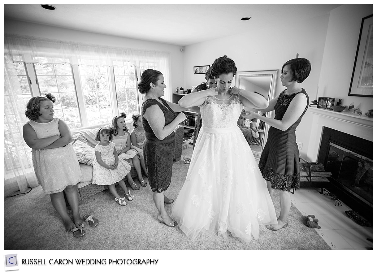 Bride getting into wedding dress