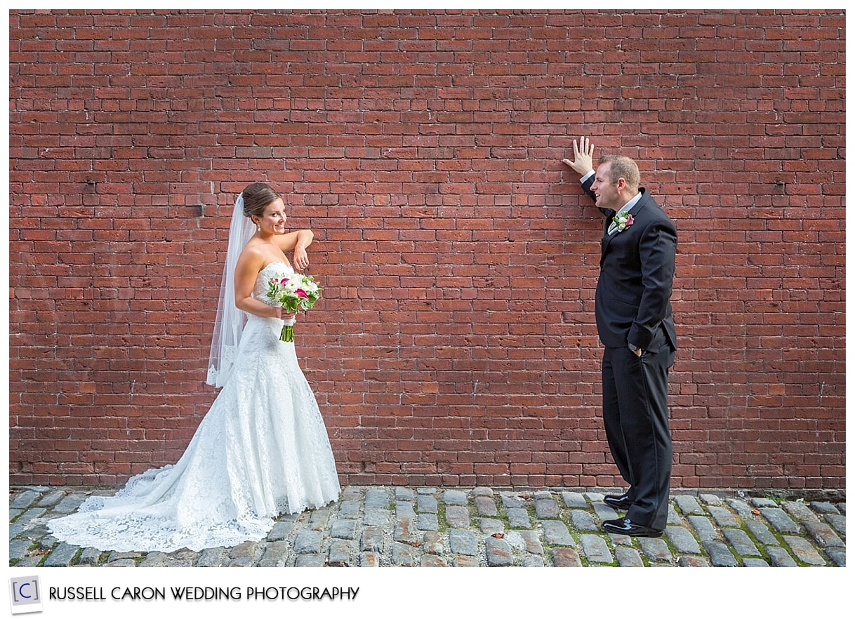 Bride and groom against brick wall