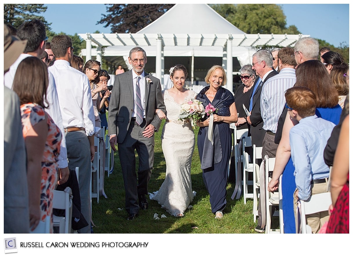 Bride being escorted down aisle by parents