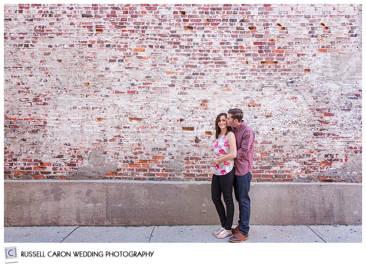 Couple standing in front of a brick wall