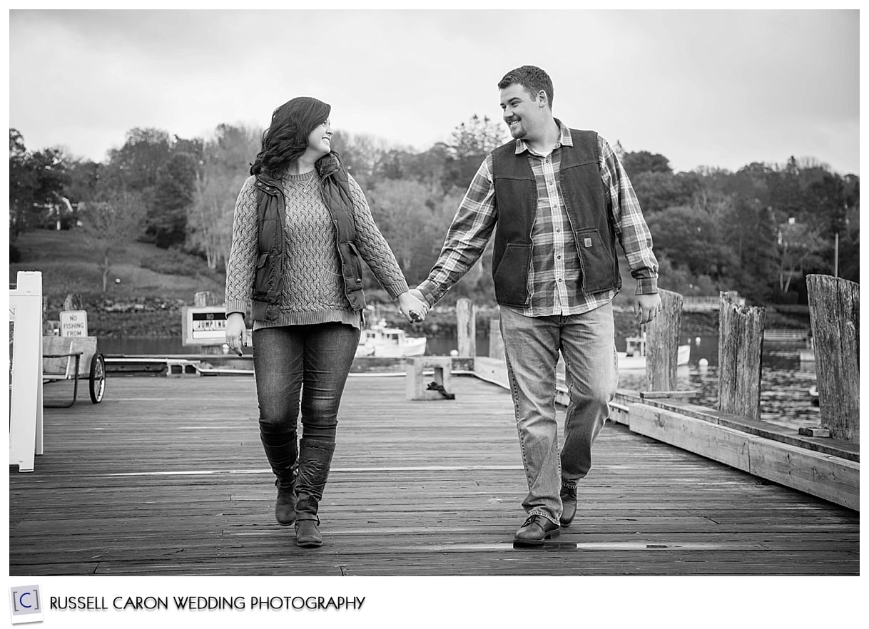 Couple walking hand in hand on a dock
