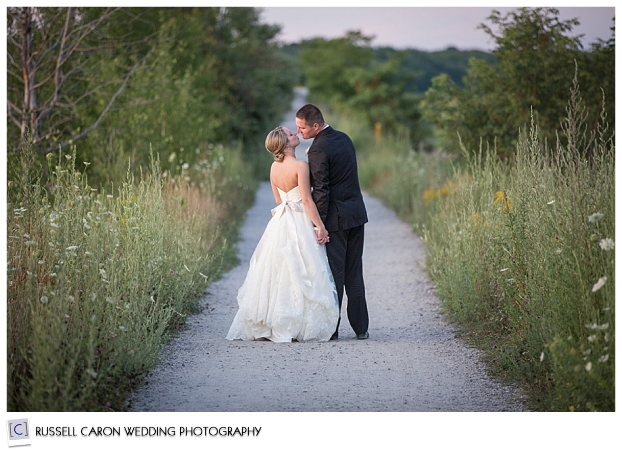 Bride and groom walking on path hand in hand