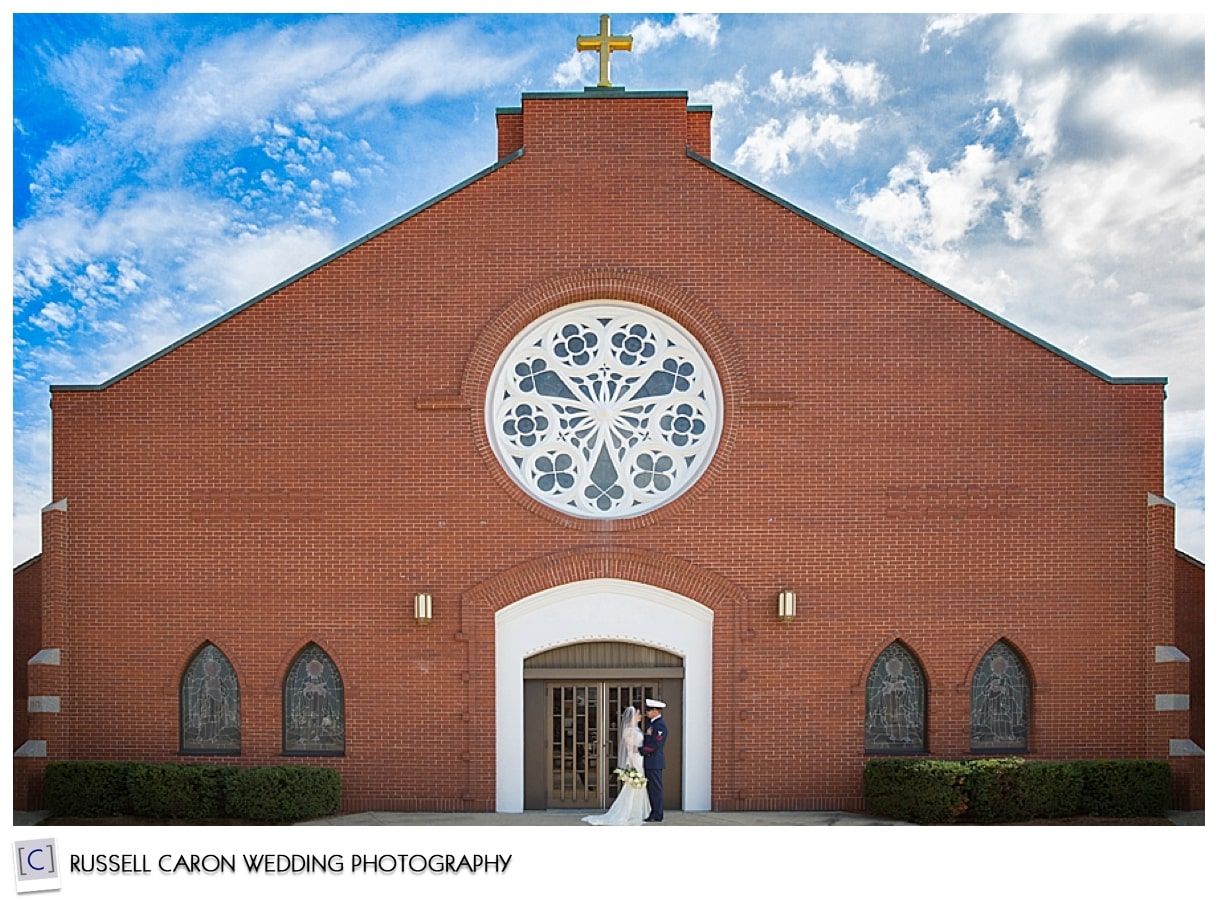 Bride and groom kissing in front of church