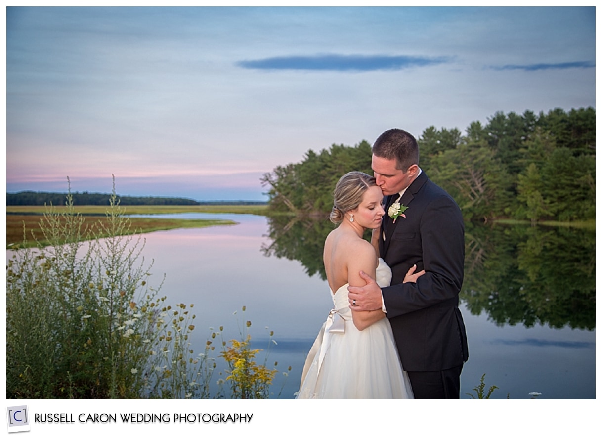 Bride and groom embracing at sunset