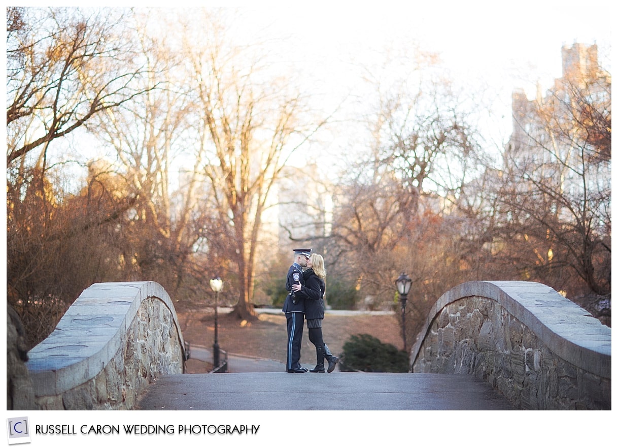 Couple embraces on bridge in Central Park