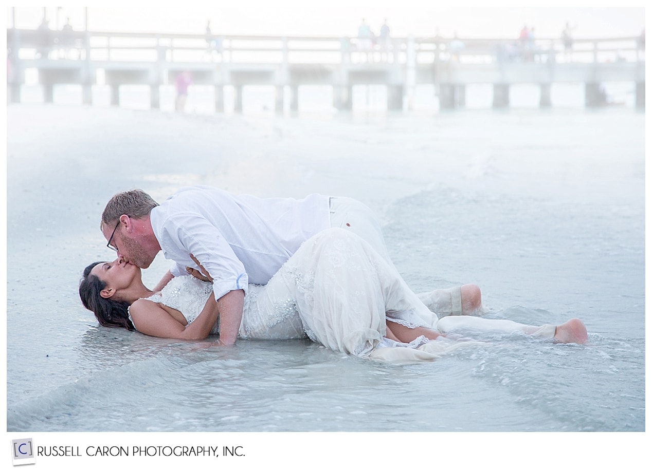 Bride and groom kissing on the beach