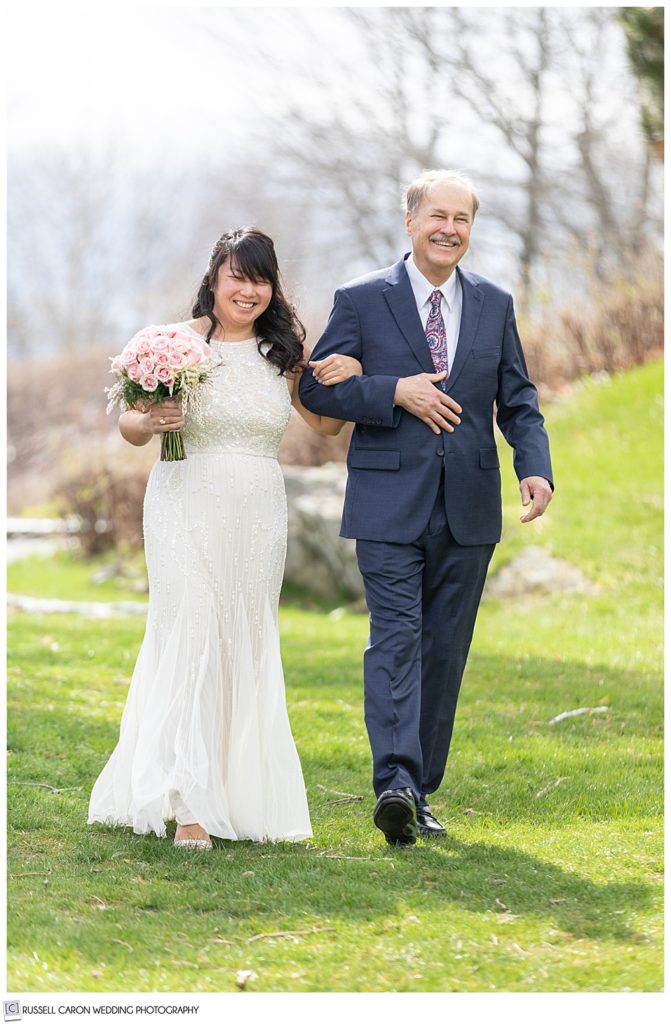 bride and her dad walk down outdoor aisle