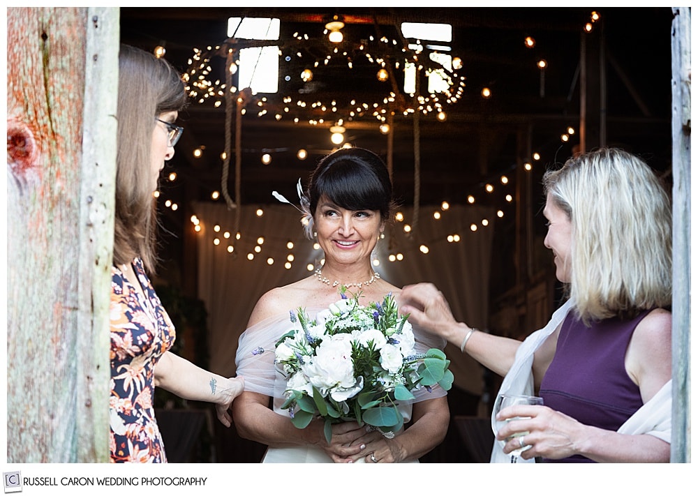 A pensive bride stands with two friends