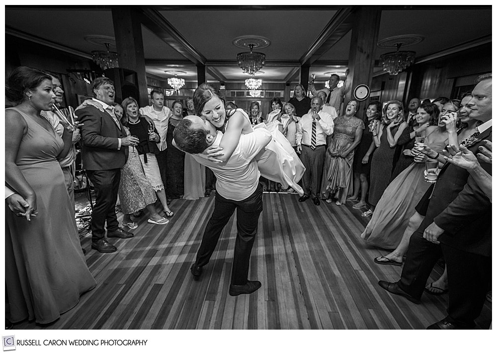 Black and white awesome wedding dance photo of groom swimming bride around the dance floor