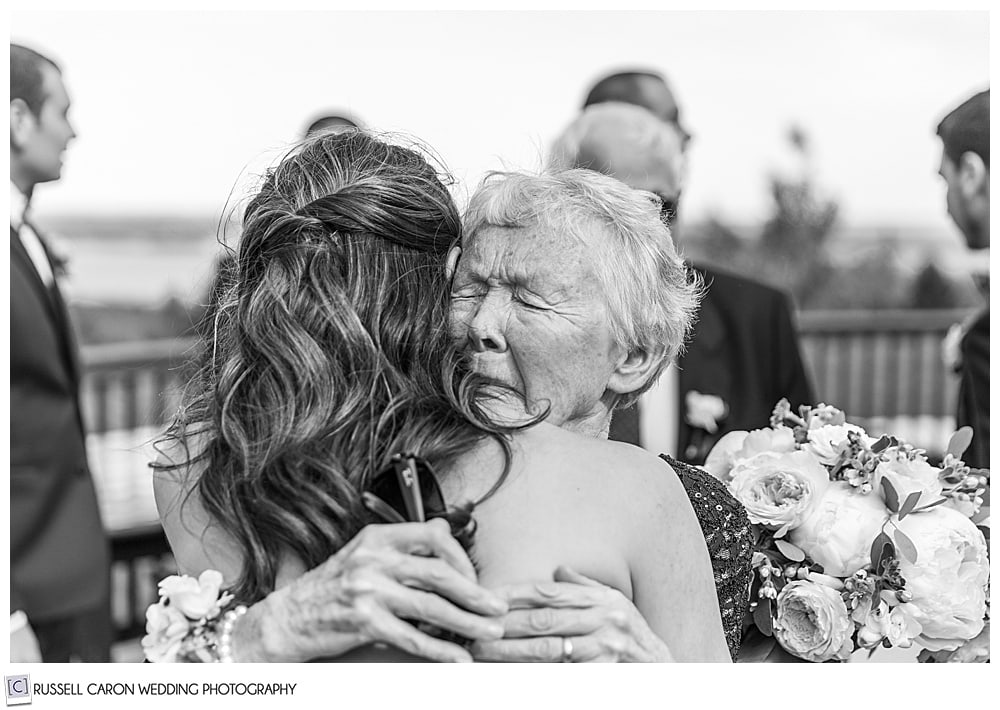 Emotional Grandmother's embrace, a black and white photo of a grandmother hugging a bride