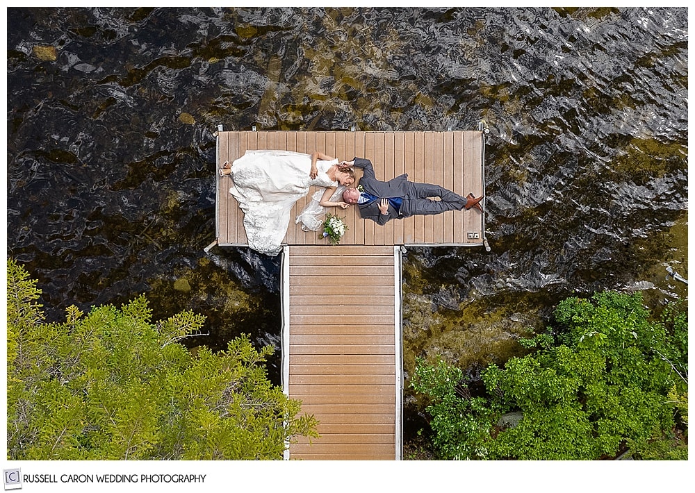 bride and groom on a dock in a Moose lake wedding drone photo