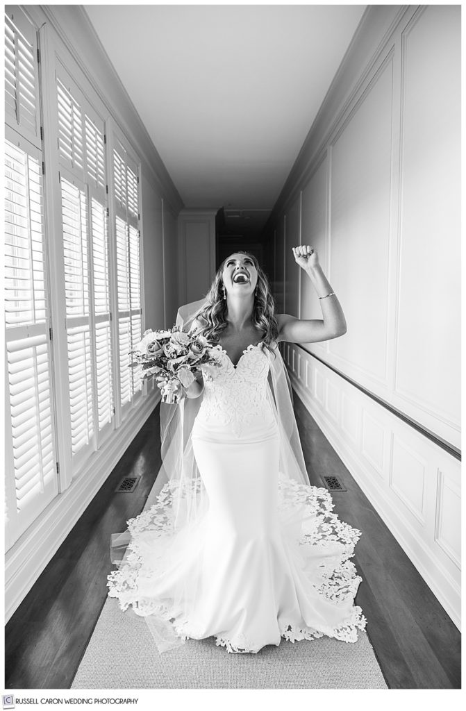 black and white photo ecstatic bride image standing in a hallway