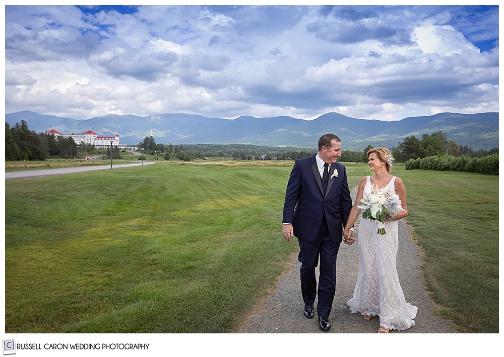 bride and groom mt washington wedding photo, bride and groom walking with Mt Washington in the background