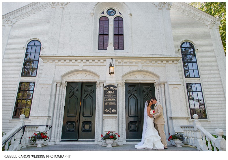 Bride and groom kissing on the steps of the First Parish Church Yarmouth Maine