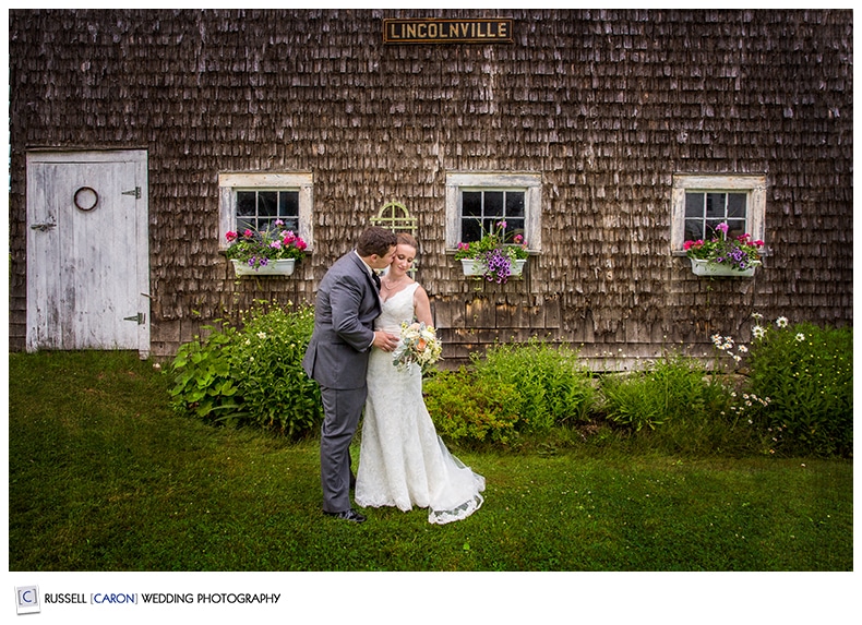 Bride and groom in front of rustic barn, Camden Maine