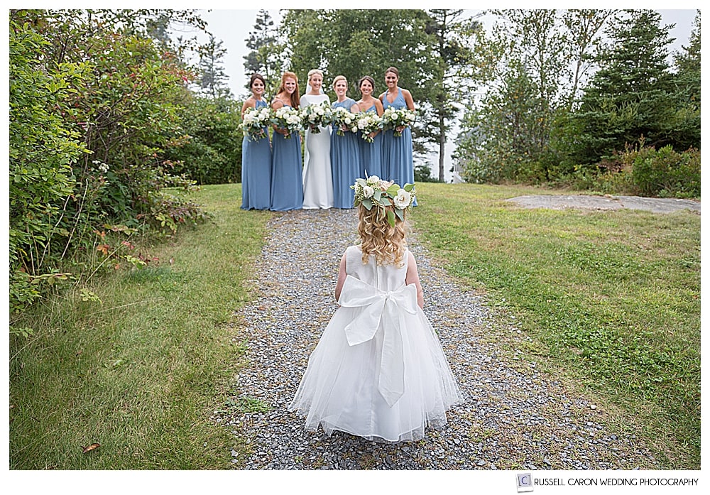 adorable flower girl photo, flower girl looking at bride and bridesmaids