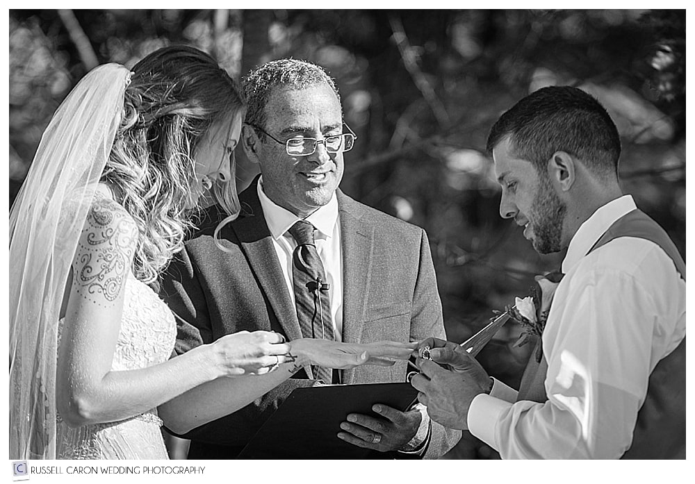 groom putting wedding ring on bride's finger