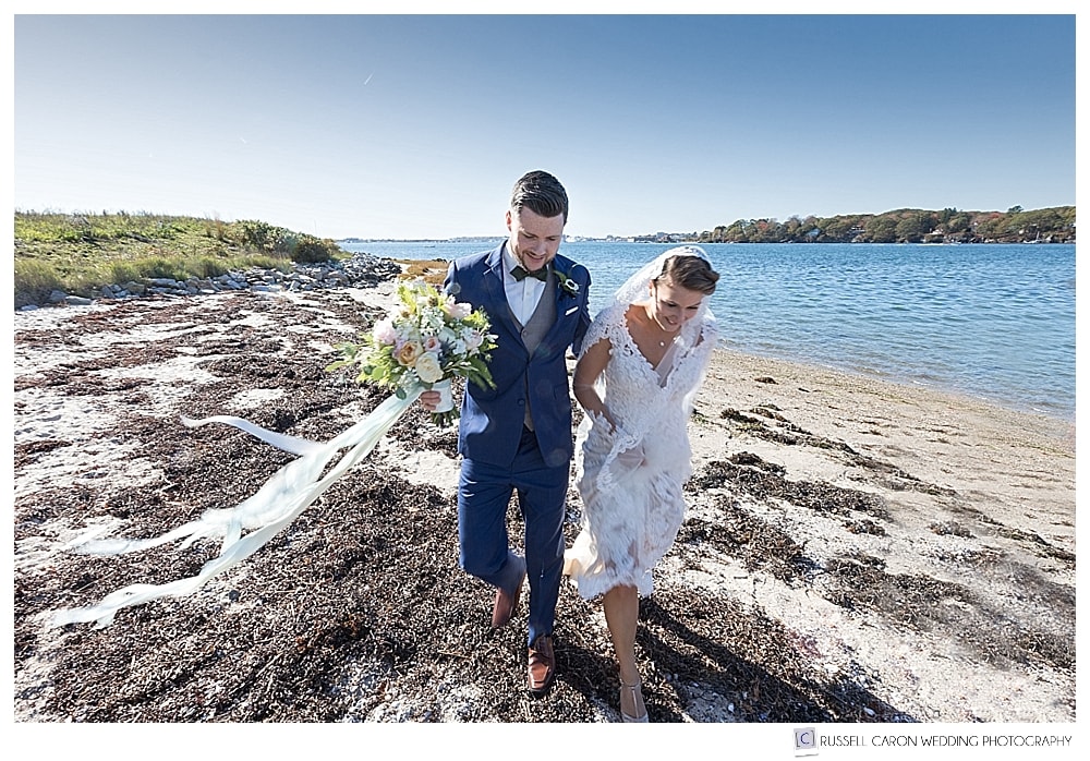 Bride and groom walking on a beach on Peaks Island Maine