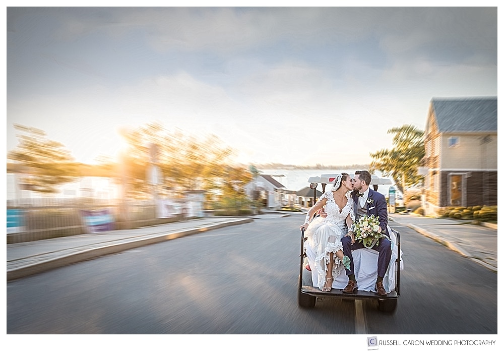 Bride and groom kissing on the back of a golf cart on Peaks Island Maine wedding