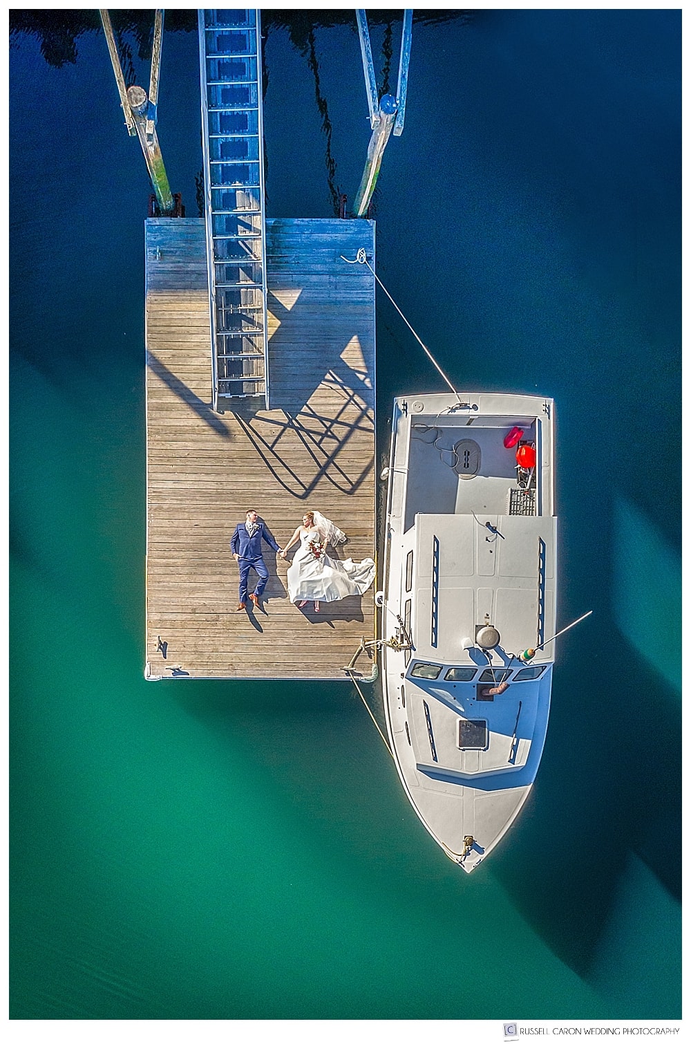 Maine drone wedding photo of a bride and groom on a dock in Camden, Maine.