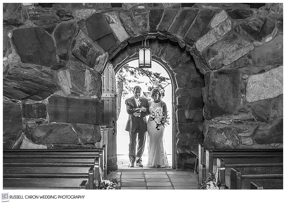 black and white photo of a bride and her father entering Saint Ann's Episcopal Church, Kennebunkport, Maine, to walk down the aisle to the groom who awaits them