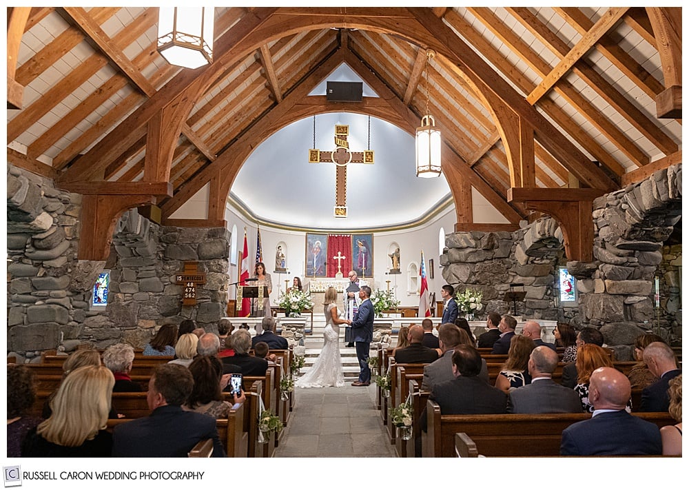 bride, groom, and congregation standing during a wedding ceremony at Saint Ann's Episcopal Church, Kennebunkport, Maine