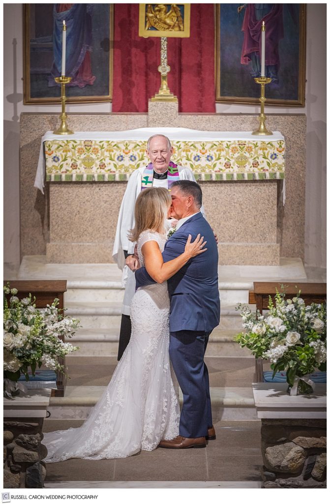 bride and groom's first kiss at the altar of Saint Ann's Episcopal Church, Kennebunkport, Maine