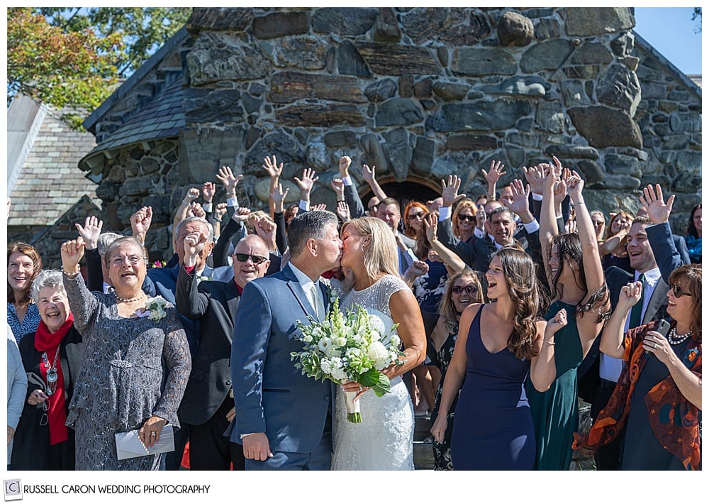 bride and groom kiss in front of Saint Ann's Episcopal Church in Kennebunkport, Maine, after their wedding ceremony