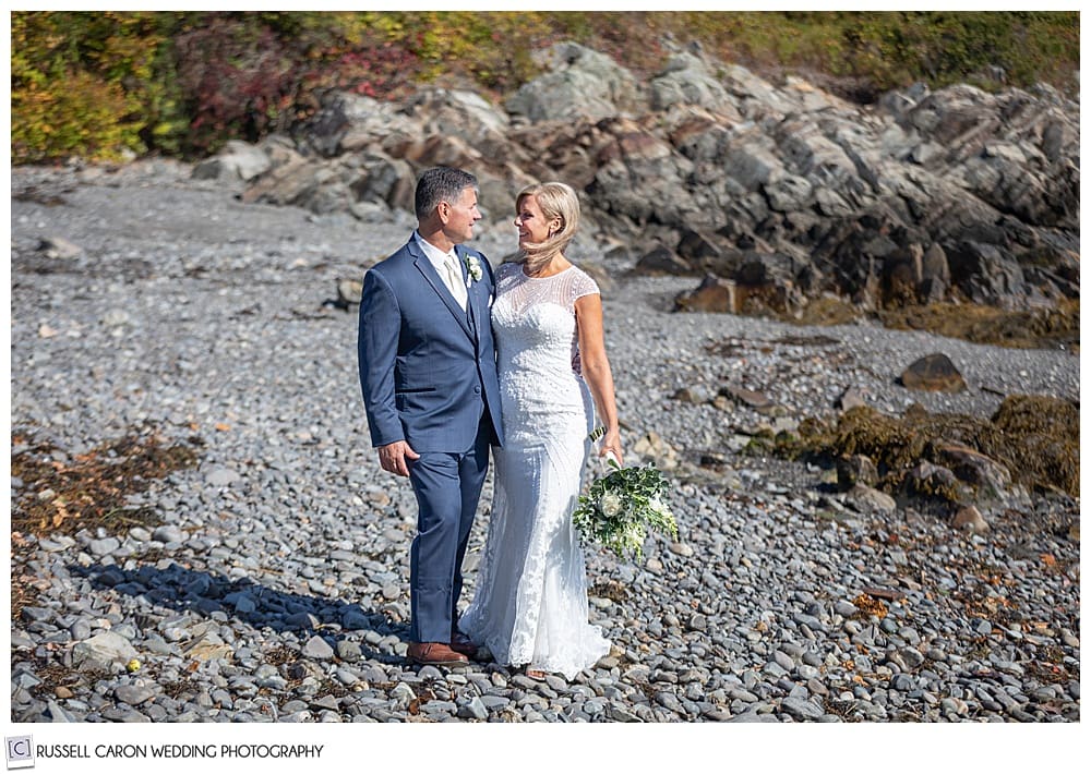 bride and groom standing side by side on a rocky beach in Kennebunkport, Maine