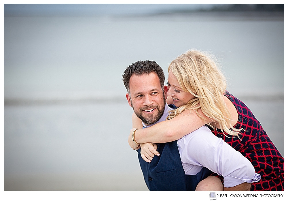 Man giving woman piggy back ride in Crescent Beach engagement photo