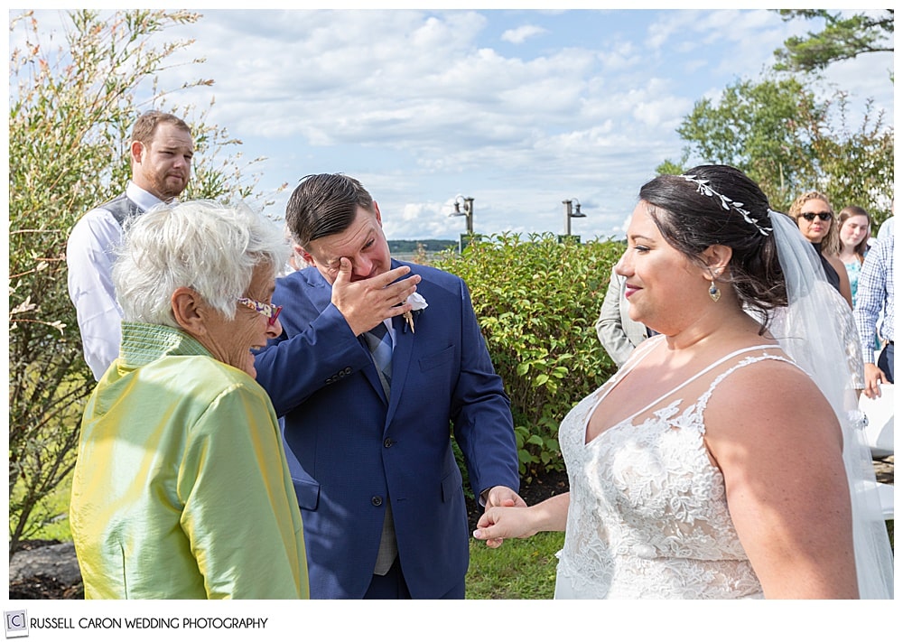 groom wiping his eyes as the bride reaches the altar