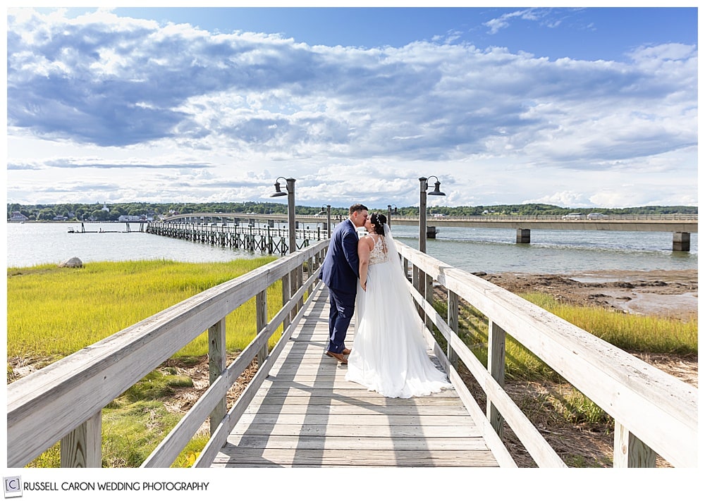 bride and groom kissing on the dock at the Sheepscot Harbour Village Resort, Edgecomb Maine wedding