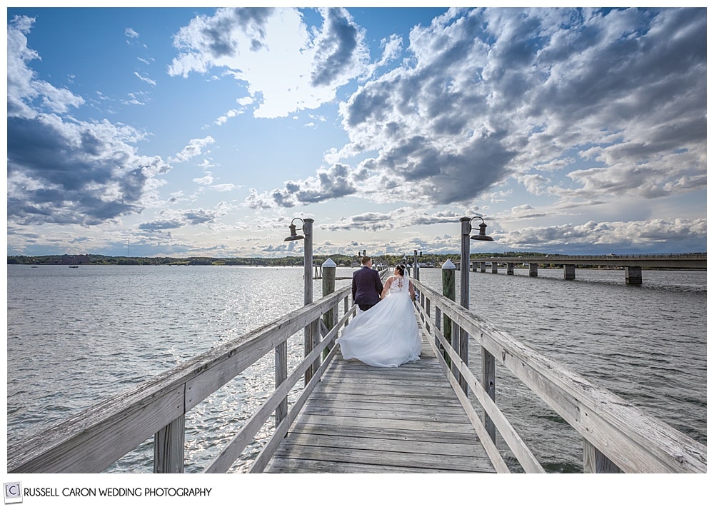 bride and groom walking on a dock after their Edgecomb Maine wedding ceremony