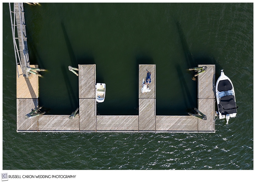 drone photo of a bride and groom on a dock