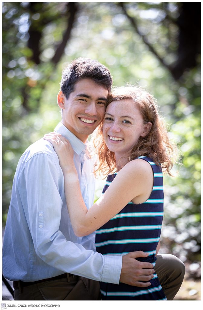 man and woman arms around each other, looking at the camera and smiling