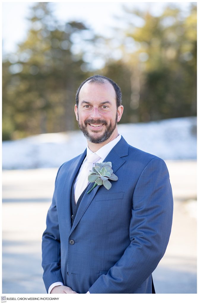 portrait of a groom wearing a blue suit