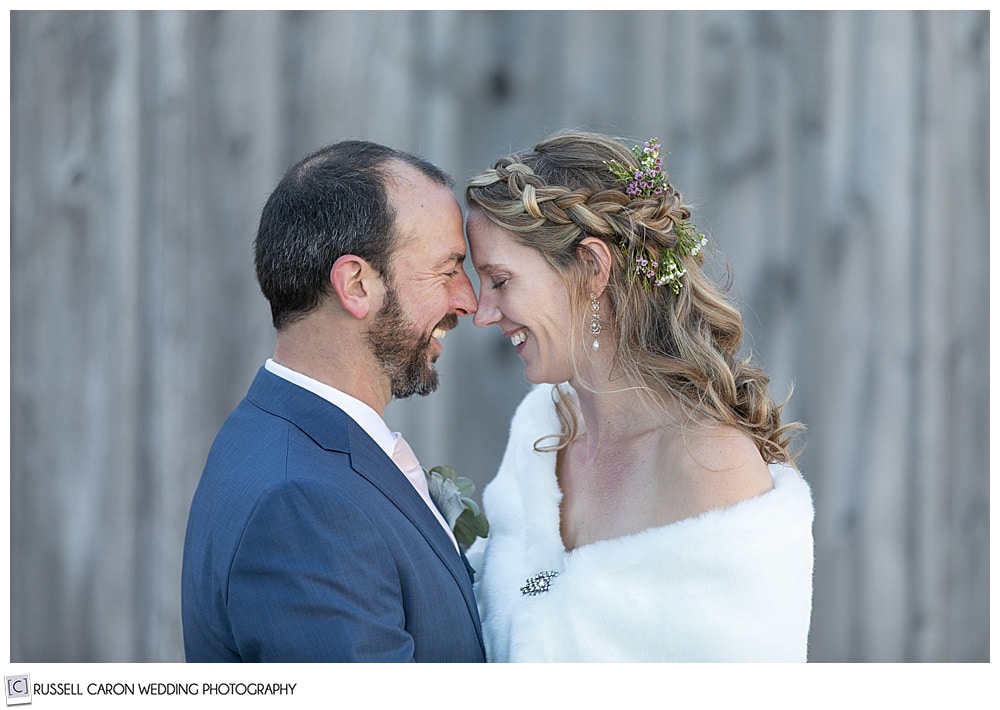 bride and groom smiling and standing with their foreheads together