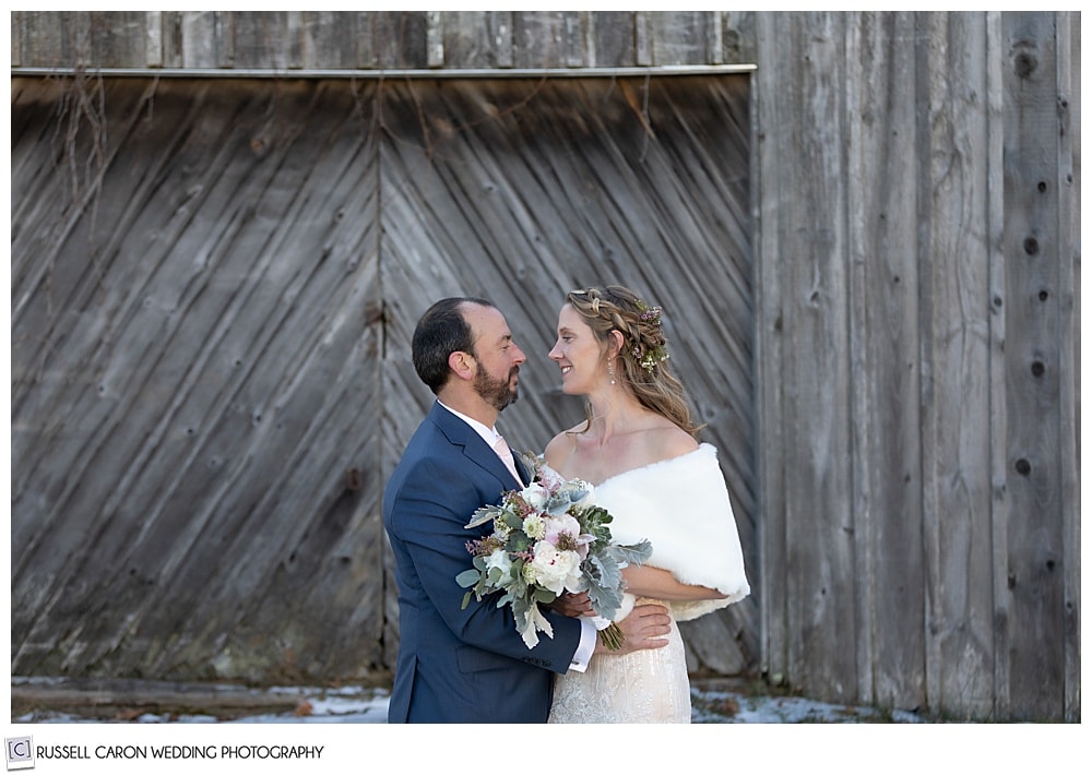 bride and groom in front of an old barn