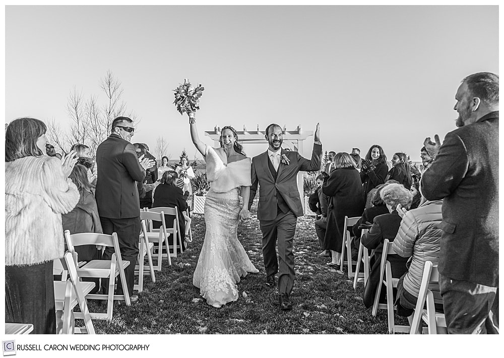 black and white photo of bride and groom during the recessional of their midcoast maine wedding ceremony