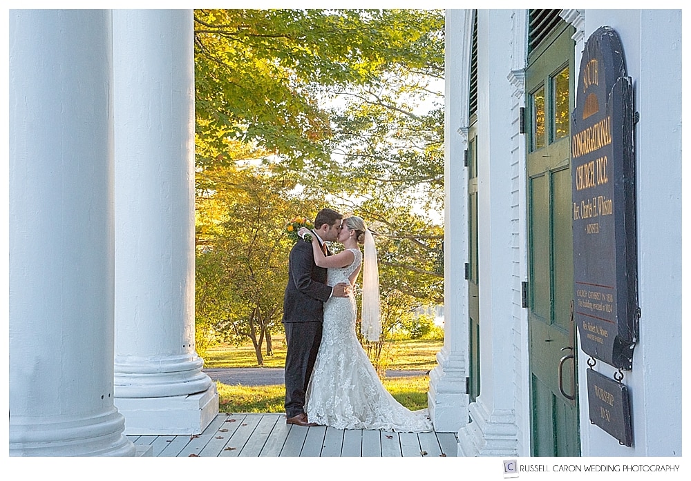 Bride and groom kissing on the porch of the South Congregational Church, Kennebunkport Maine