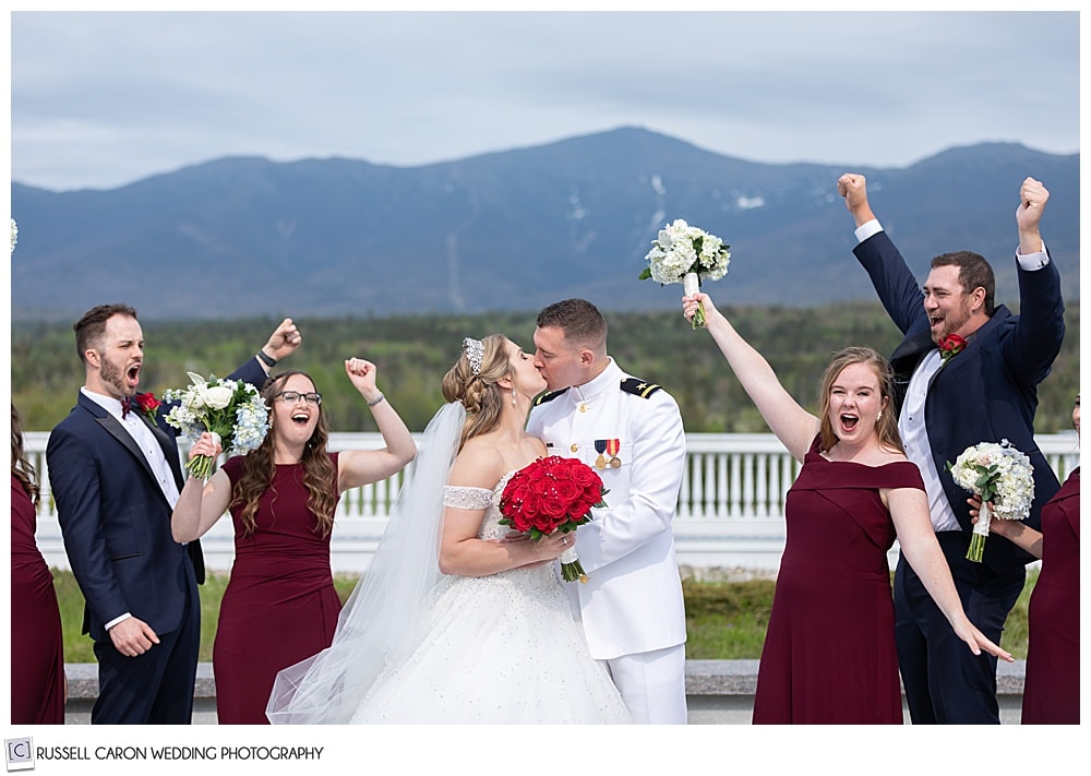 bride and groom kissing while bridal party cheers, at the Omni Mt. Washington Resort, Bretton Woods, New Hampshire