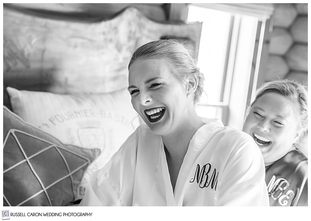 black and white photo of bride laughing with bridesmaid