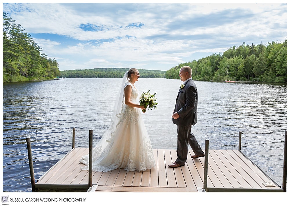 bride and groom on a dock in a lake, walking towards each other during a first look