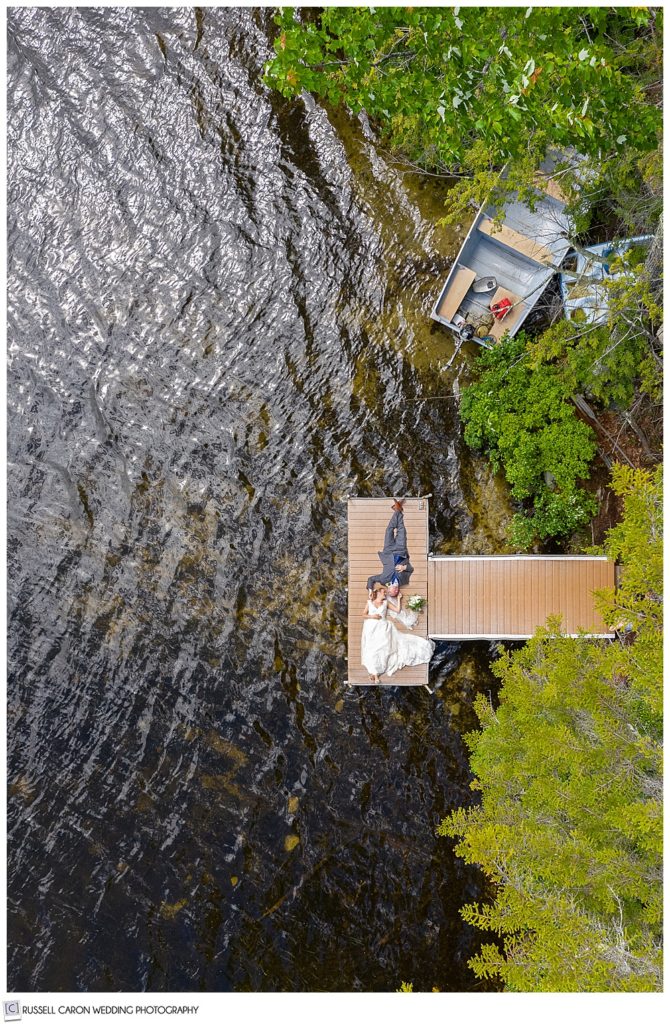 drone photo of bride and groom on a dock on a lake