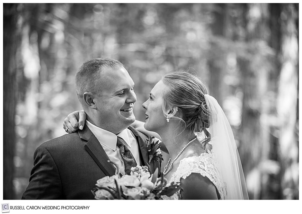 black and white photo of bride and groom smiling at each other