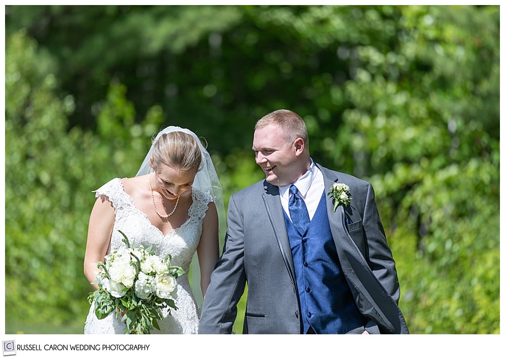 bride and groom walking side by side, groom looking at bride, bride looking down